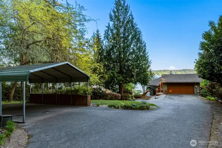 Exterior setting with ample parking, landscaped grounds, and attached garage.