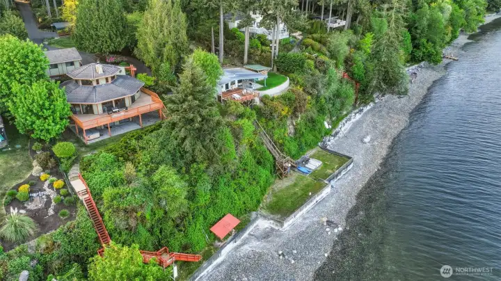 Aerial view showcasing the home’s waterfront setting and surrounding shoreline.