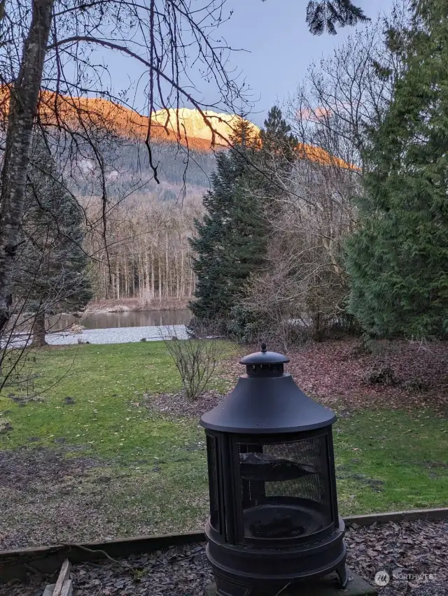 NOT SO MUCH SNOW IN YOUR YARD, WHILE SNOW IS IN MOUNTAINS. Sit around firepit all seasons with your family and friends to savor smores and hot dogs while enjoying the alpenglow in Fall, Winter and Spring. Mt. Sauk has snow at 5,500 feet, while yard is at 215 feet, and receives warmth off water. However, snow does come to lawn for a few weeks, killing insects, so your furry friends can live and play outdoors.