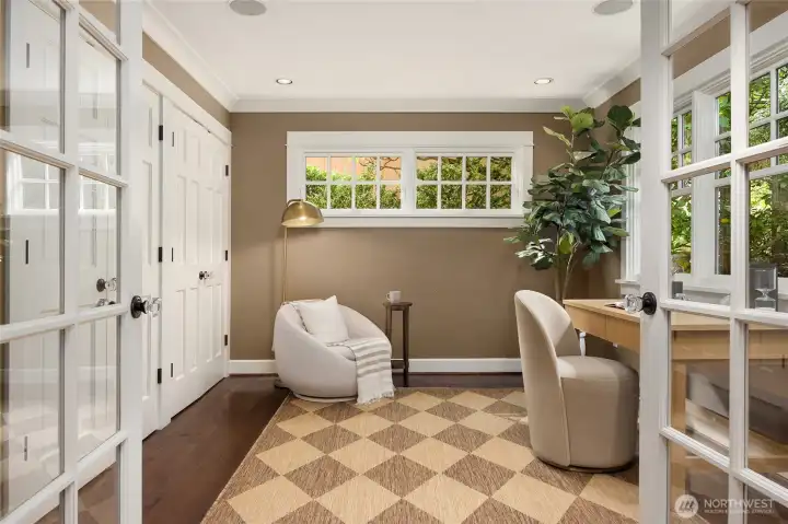 Main floor office with divided light French doors faces the front of the home.