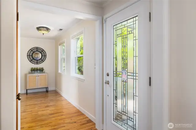 Well lit entry off of a covered porch with a coat closet and foyer space.