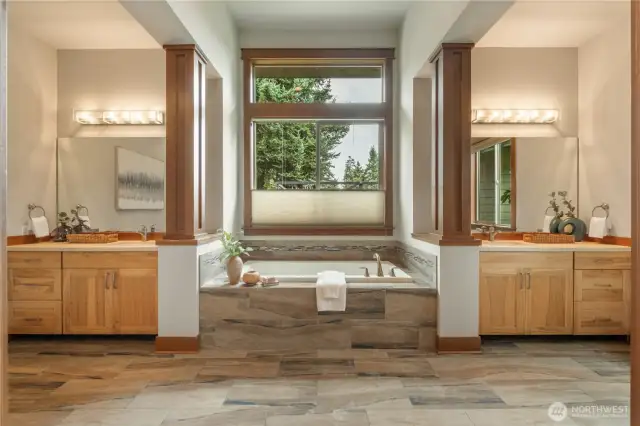 Dual vanities flank a beautifully appointed soaking tub.