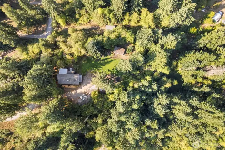 This place is ideal self-reliance: Well-draining soil, greenhouse, productive garden, fruit trees, multiple water storage tanks, Two insulated storage sheds, Several outbuildings, RV parking