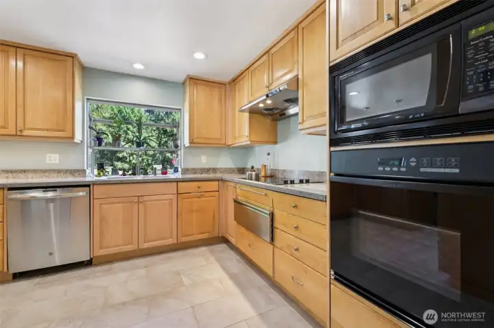 Well laid out kitchen has tons of cabinets, plant window to grow your own herbs, cooktop and warming drawer, built in oven and microwave.