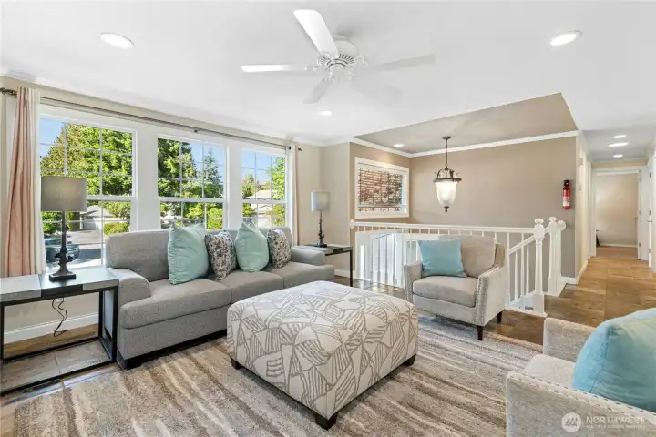 Large living room with ceiling fan and beautiful slate flooring. Open view to entry and hallway adds welcoming flow.