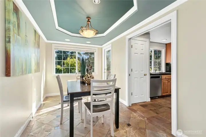 Dining room with dramatic tray ceiling and backyard view opens to the deck. Pocket doors provide optional separation from the kitchen.