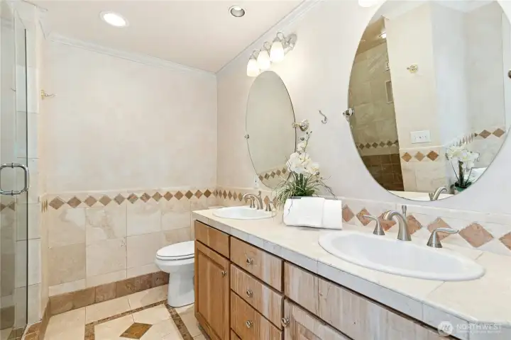 Spa inspired primary bathroom with dual sinks, double shower, and deep soaking tub.