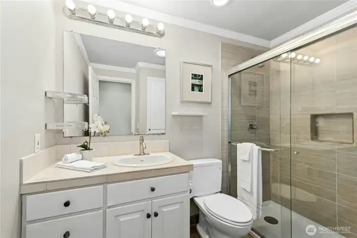 Upstairs hall bathroom has tastefully updated shower and solar tube for natural light.