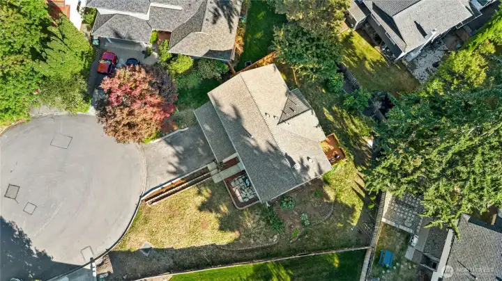 Aerial view shows this home’s large lot with spacious front and side yards plus a long driveway offering plenty of parking.