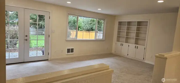 living room with french doors that opens to a huge fenced back yard note the beautiful french doors.