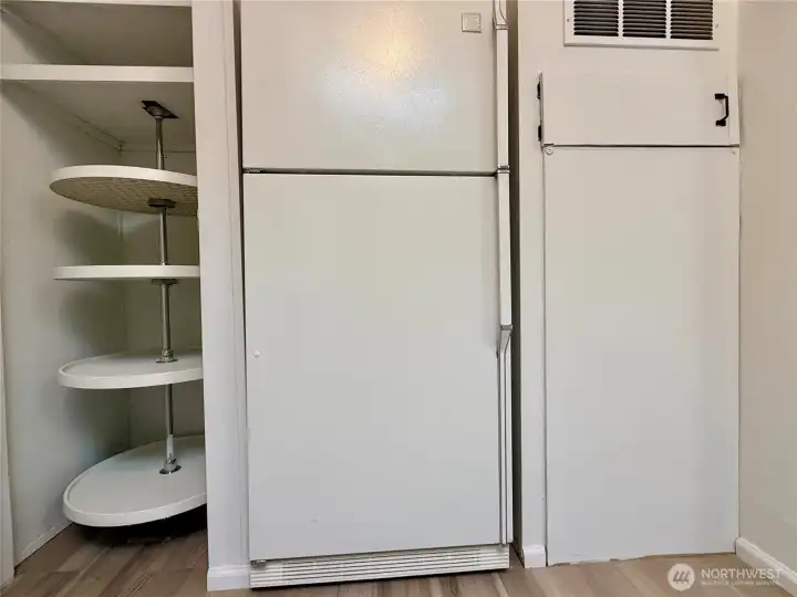 Kitchen pantry with lazy Susan shelving, and refrigerator.