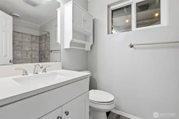 Primary ensuite full bath with upgraded quartz countertops.