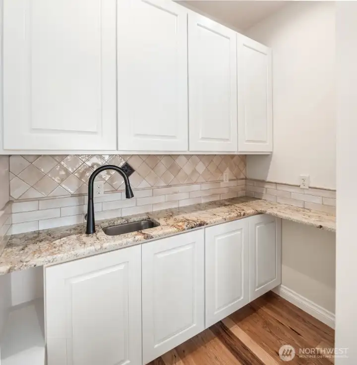 Coffee bar and pantry adjacent to gourmet kitchen for easy access and convenience Coffee bar and pantry adjacent to gourmet kitchen for easy access and convenience