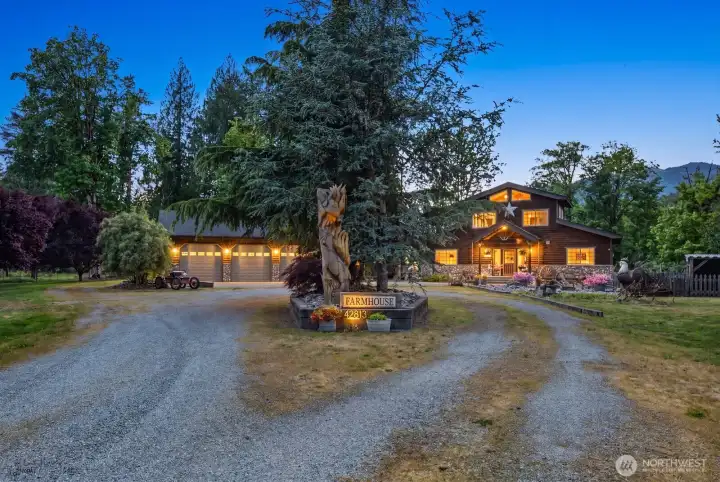 grand entryway with circular driveway surrounded by beautiful gardens