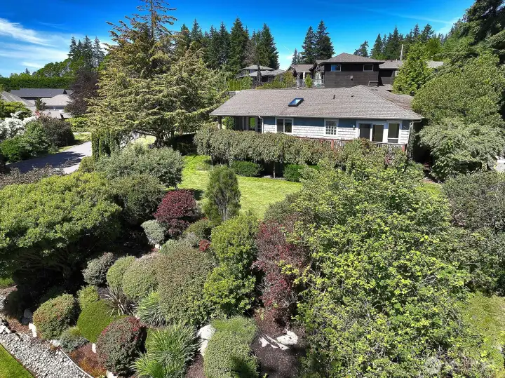 Sitting above the street level the pretty setting screens the house and the elevation helps tuck the house into this corner lot.