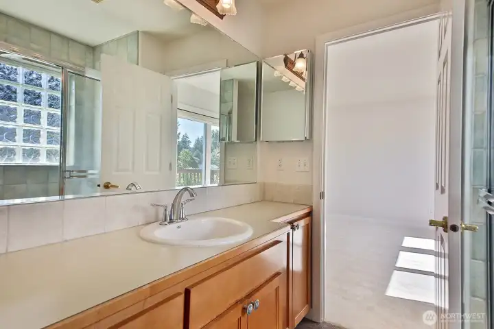 Shower with glass block window and slate tile flooring in the bathroom.