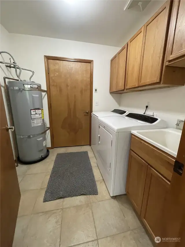 Laundry room off of primary bedroom with exit door to garage