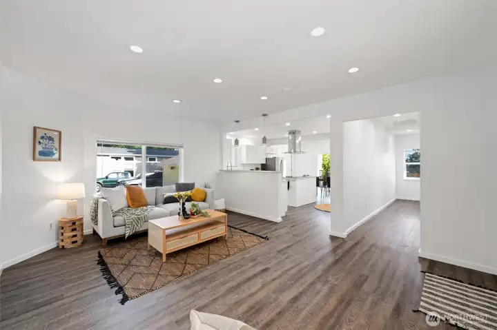 The living room is spacious and open to the kitchen and dining area beyond. Down the hallway to the right is the 2nd bedroom, 3/4 bath and laundry area.