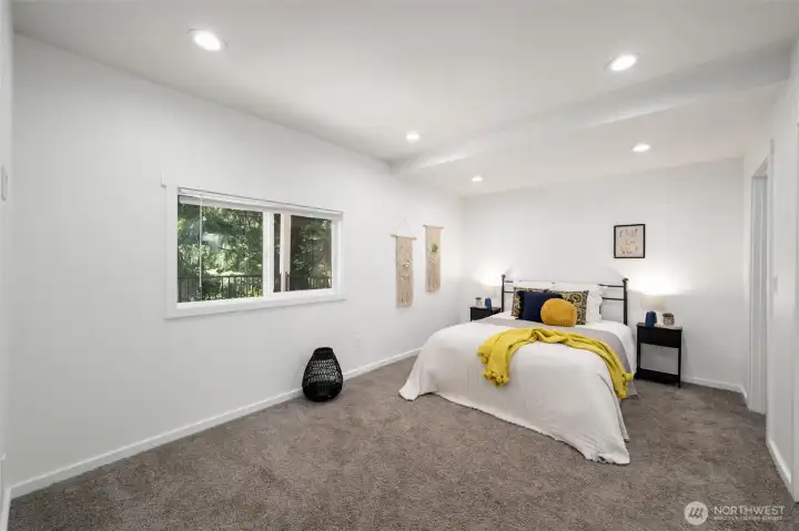 The primary suite is very spacious and looks out toward the evergreens.