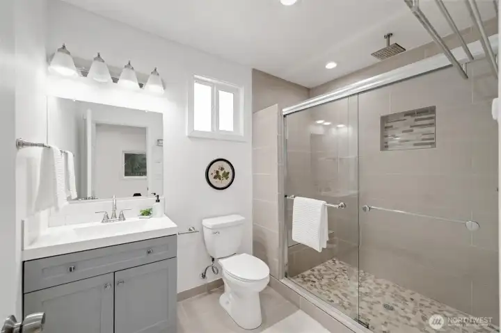 The primary bath has an oversized tiled shower with a sliding glass door. This has all been updated.