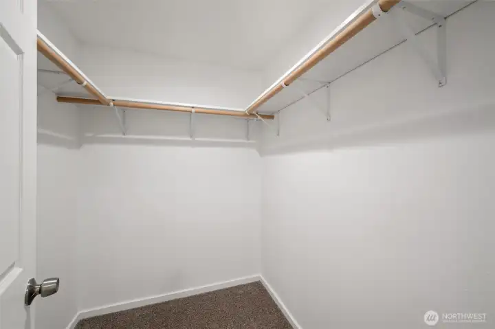 The walk-in closet in the primary bedroom is spacious and there is a lot of hanging space.
