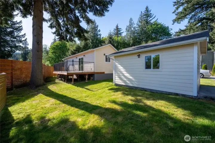 Looking at the privately situated home and shop with the evergreens beyond.