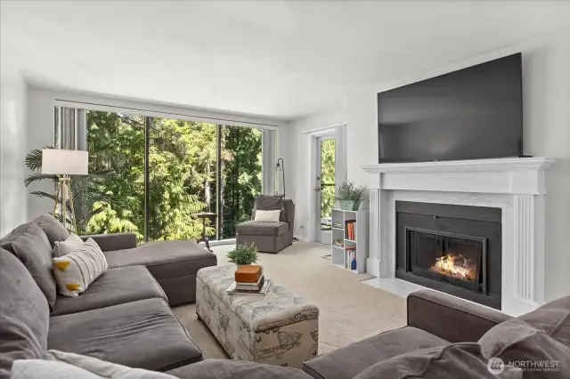Living room w/cozy fireplace and beautiful wooded outlook