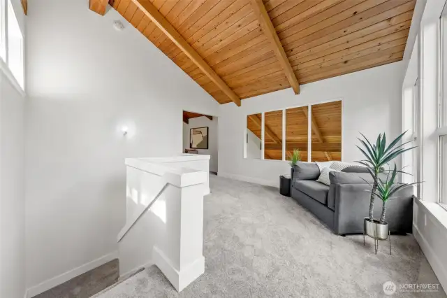 Tucked above the main living spaces, this spacious loft offers a quiet spot for reading, reflection, or unwinding—framed by soaring ceilings and natural light.