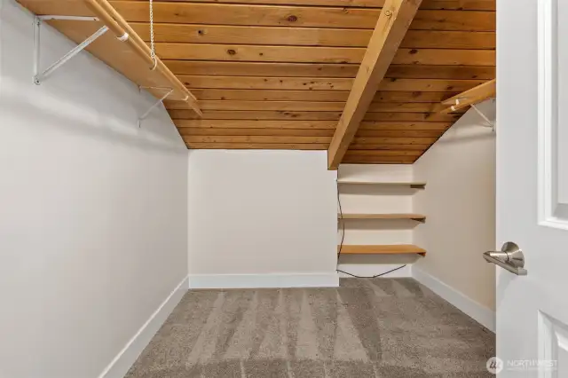 Rustic charm meets utility in this second walk-in closet, complete with built-in shelving.