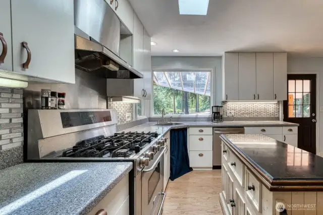 The nice 5 burner propane stove, and kitchen sink looks out to the beautiful setting.
