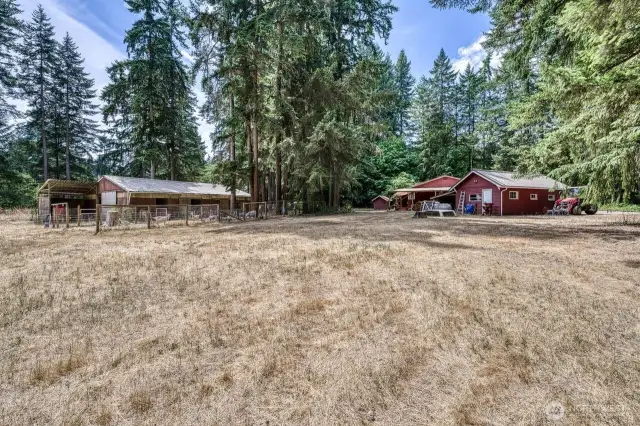 The view of the barn, one car garage and house.