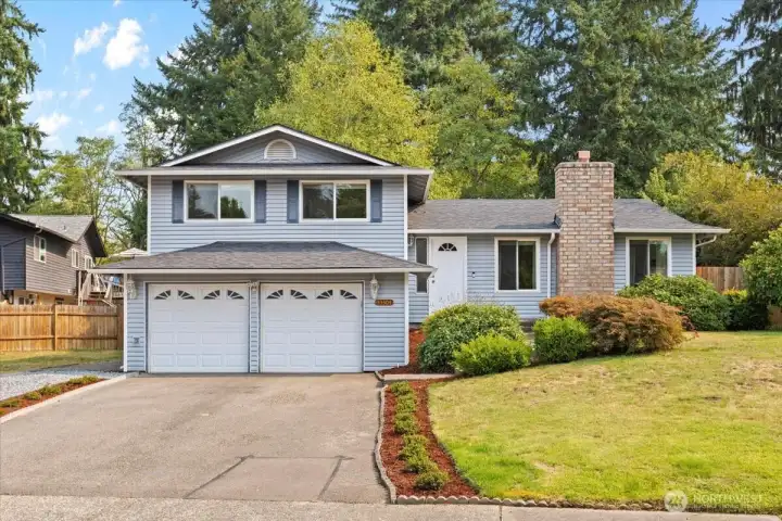 Charming curb appeal on a private corner lot with greenbelt backdrop.