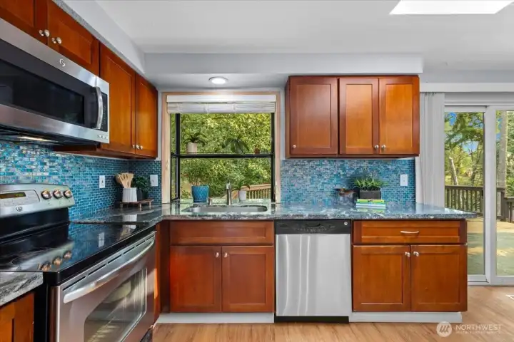 Kitchen features beautiful tile backsplash, granite counters, and stainless steel appliances.