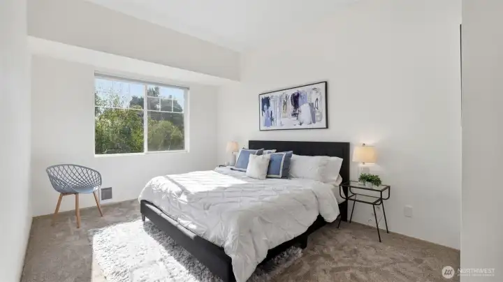 Retreat to this bright and airy primary bedroom filled with natural light and serene views.