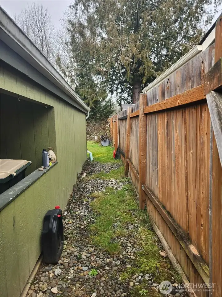 Gated and graveled entrance to private backyard.