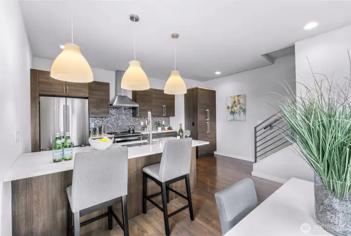 Kitchen with bar seating with stairs leading to the upper floor dedicated to the primary suite.