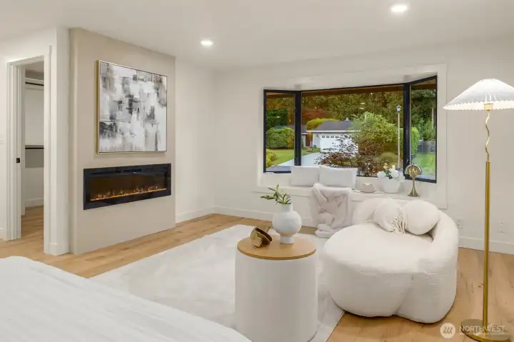 Primary suite offers sitting area in front of fireplace and Bench window.