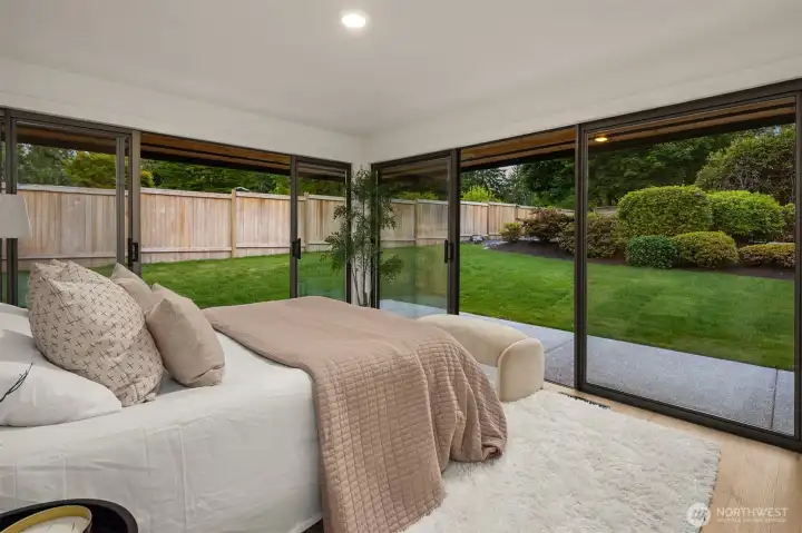 Bedroom 2 on the main level offers walls of windows overlooking the beautiful backyard - or use as a sunroom!  (Want a more traditional bedroom w/o all the windows??? CAN DO!! (for a small fee - call broker for more info)