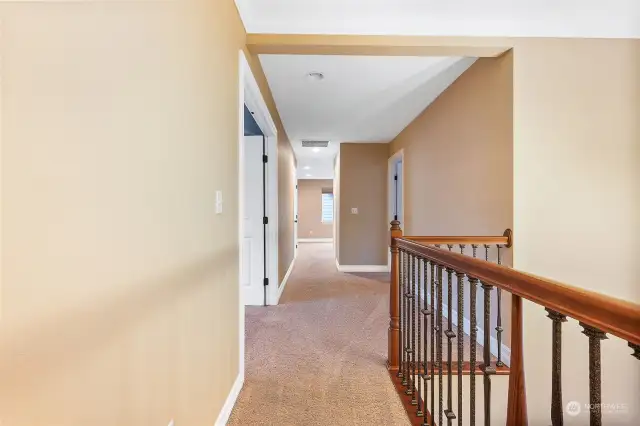 Upstairs hallway leads to all bedrooms.  Overlooking wrought iron railing is the beautiful entryway.