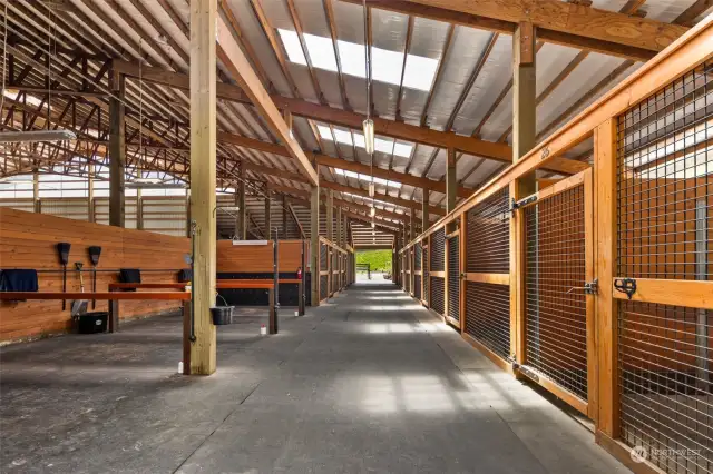 31 interior stalls with custom blanket lockers, one stall is converted to a 12 x 12 fully enclosed Equivibe, 2 rubber matted hot/cold wash racks, 2 oversized vet and farrier cross tie bays, (bay 2 equipped with Drimee Sirocco infrared therapy solarium with heating and cooling)