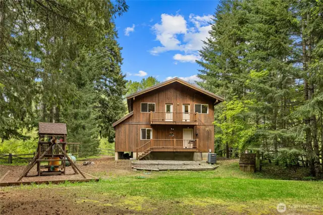 Large backyard with playset and storage shed