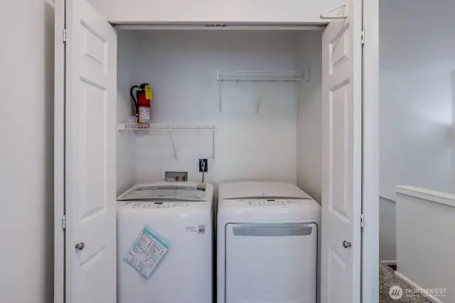 Laundry closet with digital appliances and storage conveniently located near bedrooms.