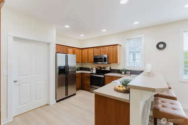 This well-equipped kitchen features an abundance of cabinetry—perfect for keeping dishes, cookware, and all your kitchen essentials neatly tucked away. Ample counter space and an electric range make it easy to prep, cook, and gather with ease.