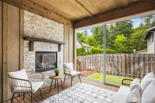 Charming enclosed patio with fireplace—ideal for relaxing or entertaining year-round, with protection from the elements and views of the backyard.