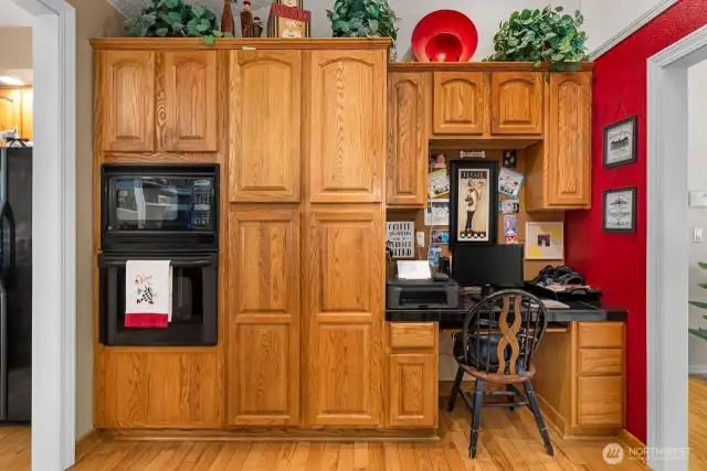 The extended kitchen area boasts hardwood flooring, an in double wall microwave, oven, and pantry sized cabinets.  Imagine a beverage fridge built in below the desk area! This would make a fabulous bar space!