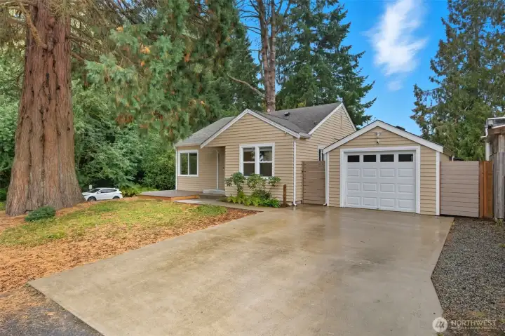 This home’s landscaping features a stately sequoia and lush surroundings, enhanced by the green space of Forest Ridge Park next door