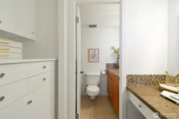 Primary en suite bath with built-in closet drawers and vanity