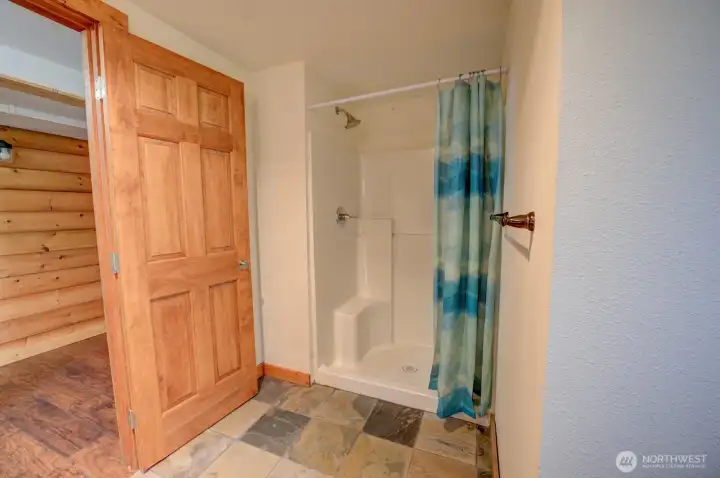 Lower level bathroom - walk-in shower tucked into cove of room. Has some rest bench/shelf and wash cloth bar.