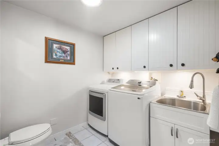 The laundry offers full-sized units, a sink, 2nd toilet and storage.