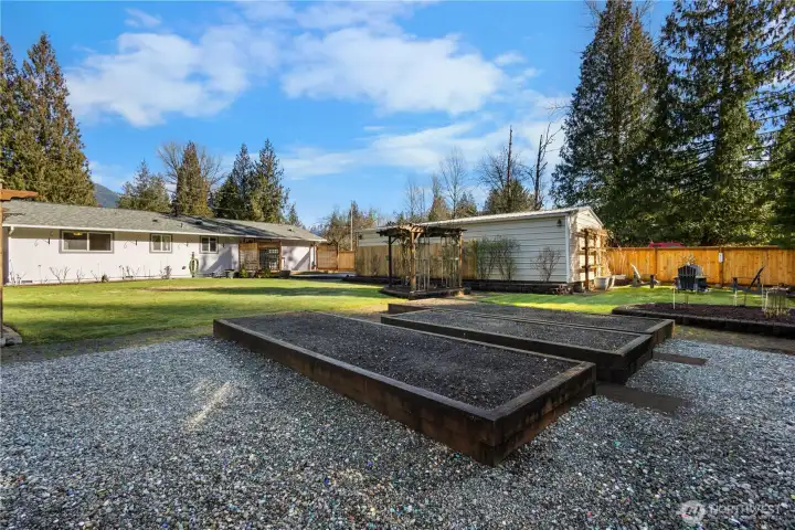 The garden beds are ready for your vegetables, fruit and flowers. The backyard is drenched in afternoon sun.